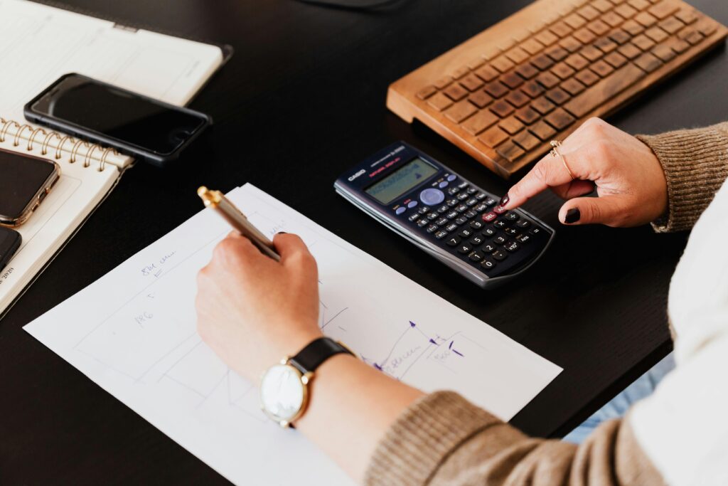 A image showing someone budgeting with a calculator